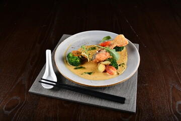deep fried salmon fish with golden salted egg yolk sauce and vegetables seafood in dark background asian halal menu