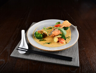 deep fried salmon fish with golden salted egg yolk sauce and vegetables seafood in dark background asian halal menu