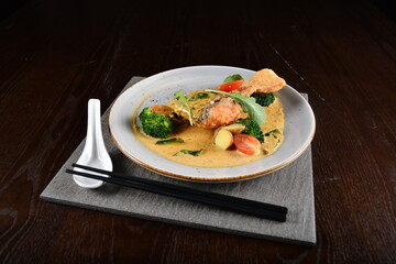 deep fried salmon fish with golden salted egg yolk sauce and vegetables seafood in dark background asian halal menu
