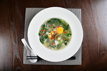 chinese wok fried water spinach vegetable with trio eggs century egg, salted egg, chicken egg and soup in plate on wood table restaurant asian cafe vegan halal menu