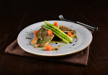 pan fried fresh grouper fish fillet seafood with asparagus and sauce main course in dark background western halal menu