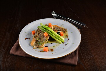 pan fried fresh grouper fish fillet seafood with asparagus and sauce main course in dark background western halal menu