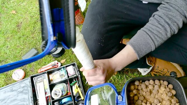 Fisherman Loading PVA Bag of Protein Balls at Woodlake's Park in Norwich, England.