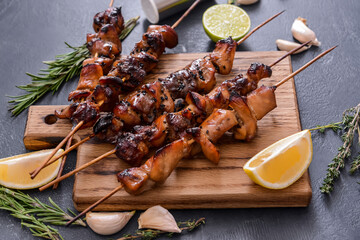 Board with tasty chicken kebab on table