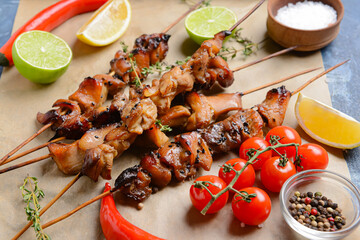 Skewers with tasty chicken kebab on color background