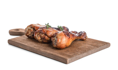 Board with roasted chicken legs on white background