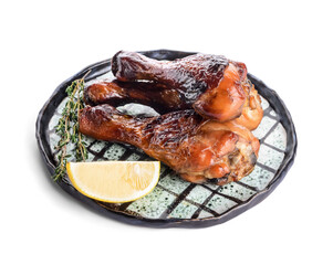 Plate with roasted chicken legs on white background
