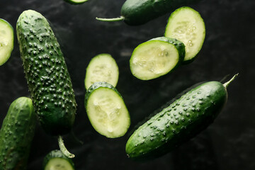 Flying cucumbers on dark background