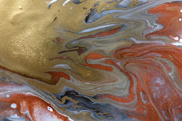 Piles of gold sequins on grey smudges of paint. Abstract pattern.