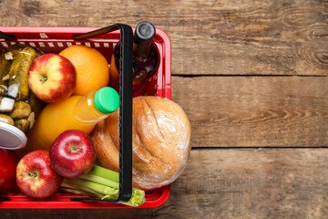 Obraz na płótnie Canvas Shopping basket with food on wooden background