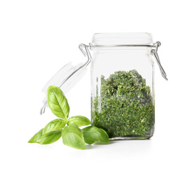Jar with fresh pesto sauce and basil leaves on white background