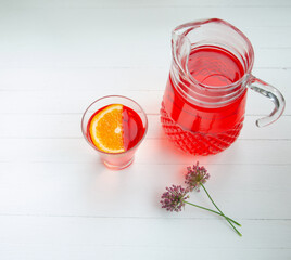 Red cherry drink in a transparent container on a white background. Summer refreshing cocktail