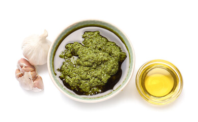 Bowl with fresh pesto sauce and garlic on white background