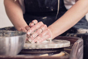 Female Potter creating a earthen jar on a Potter's wheel