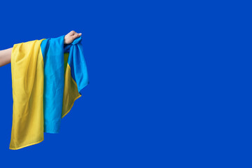 Female hand with flag of Ukraine on color background