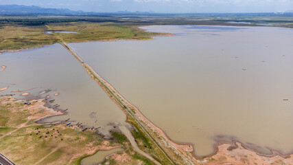 Aerial Unseen view of railroad tracks of floating Train bridge with white car in Khok Salung, Pa Sak Jolasid dam Lopburi amazing Thailand, Known as a floating train route.