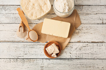Composition with fresh and dry yeast on light wooden background