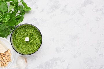 Cooking basil pesto in blender bowl and ingredients with copy space