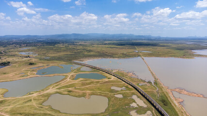 Aerial Unseen view of railroad tracks of floating Train bridge with white car in Khok Salung, Pa...