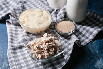 Bowls with fresh and dry yeast on color background