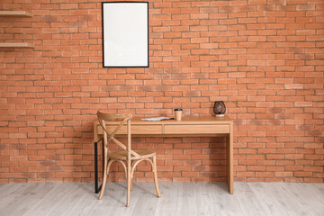Interior of modern room with comfortable workplace and blank photo frames