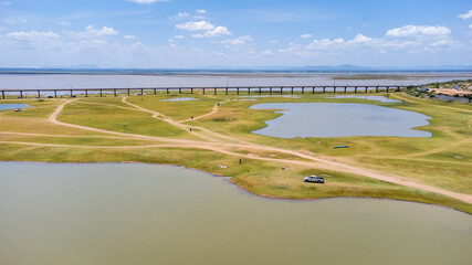 Aerial Unseen view of railroad tracks of floating Train bridge with white car in Khok Salung, Pa...