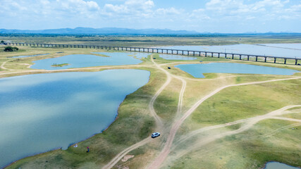 Aerial Unseen view of railroad tracks of floating Train bridge with white car in Khok Salung, Pa...