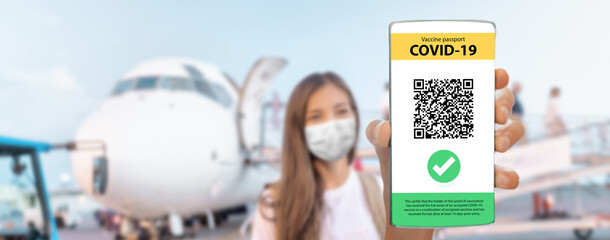 COVID-19 Travel vaccine passport tourist woman wearing mask arriving by plane showing immunization...