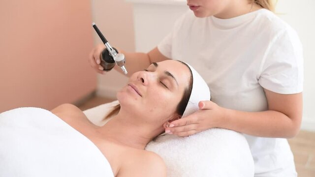 Injection oxygen spray nano moisturising atomiser facial  rejuvenation cleaning and moisturise nourish skin of face. Beautiful woman receiving treatment skin care in cosmetology spa salon