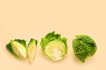 Pieces of fresh savoy cabbage on color background