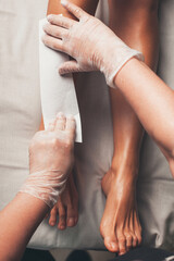 Upper view photo of a caucasian woman having leg depilation procedures in a spa salon