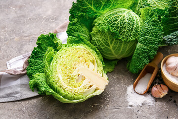 Obraz premium Half of fresh savoy cabbage on grunge background