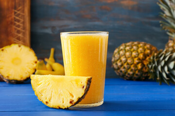 Fototapeta na wymiar Glass of tasty pineapple smoothie on color wooden background