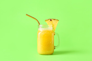 Mason jar of tasty pineapple smoothie on color background