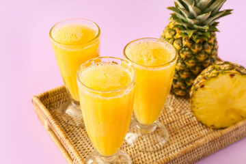 Glasses of tasty pineapple smoothie on color background, closeup