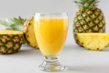 Fototapeta na wymiar Glass of tasty pineapple smoothie on grey background, closeup