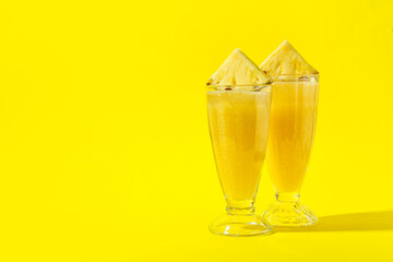 Glasses of tasty pineapple smoothie on color background