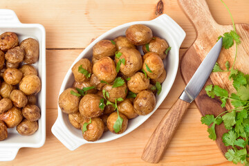 Dish with tasty baked potato on wooden background