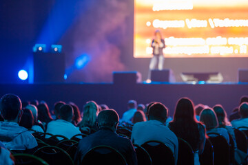 Audience listening to speaker in neon light