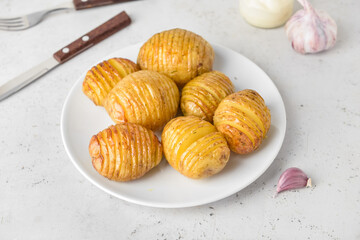 Plate with baked potato on light background
