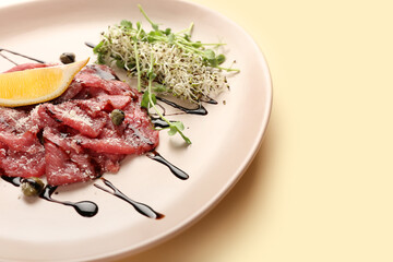 Plate with tasty veal carpaccio on color background, closeup