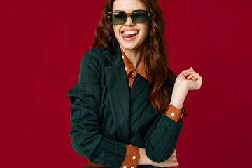 woman in suit sunglasses smile cropped view red background studio