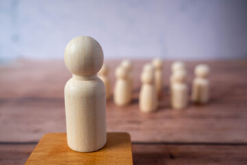 Wooden figures standing out from crowd.Depicts the ability of individual to influence and lead...