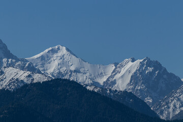 Fototapeta na wymiar View of the mountain peaks, where huge blocks of snow hang