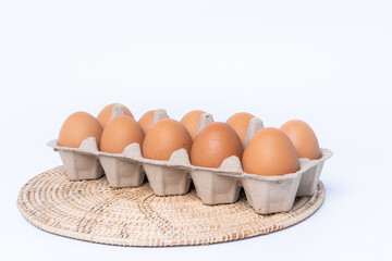 Close-up view of raw chicken eggs in egg box isolated on white background. Fresh organic chicken eggs in carton pack or egg container with copy space