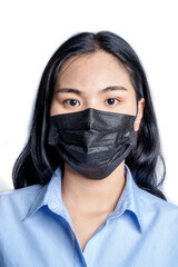 Woman wearing medical face mask isolated on white background. Dust protection against virus. Coronavirus pandemic time. Female looking at camera with black mask on her face against coronavirus disease