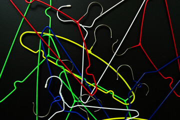 Lots of clothes hangers on a black background.
View from above.