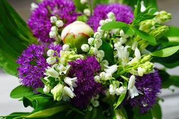 White and purple spring floral arrangement with alliums, lily of the valley and peony flowers