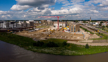 Construction site Kade Zuid part of the new Noorderhaven neighbourhood at riverbed of the  IJssel in Zutphen, The Netherlands. Aerial industrial view of building plot. Housing and urban management.