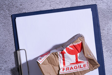  damaged parcel with fragile sticker on clipboard